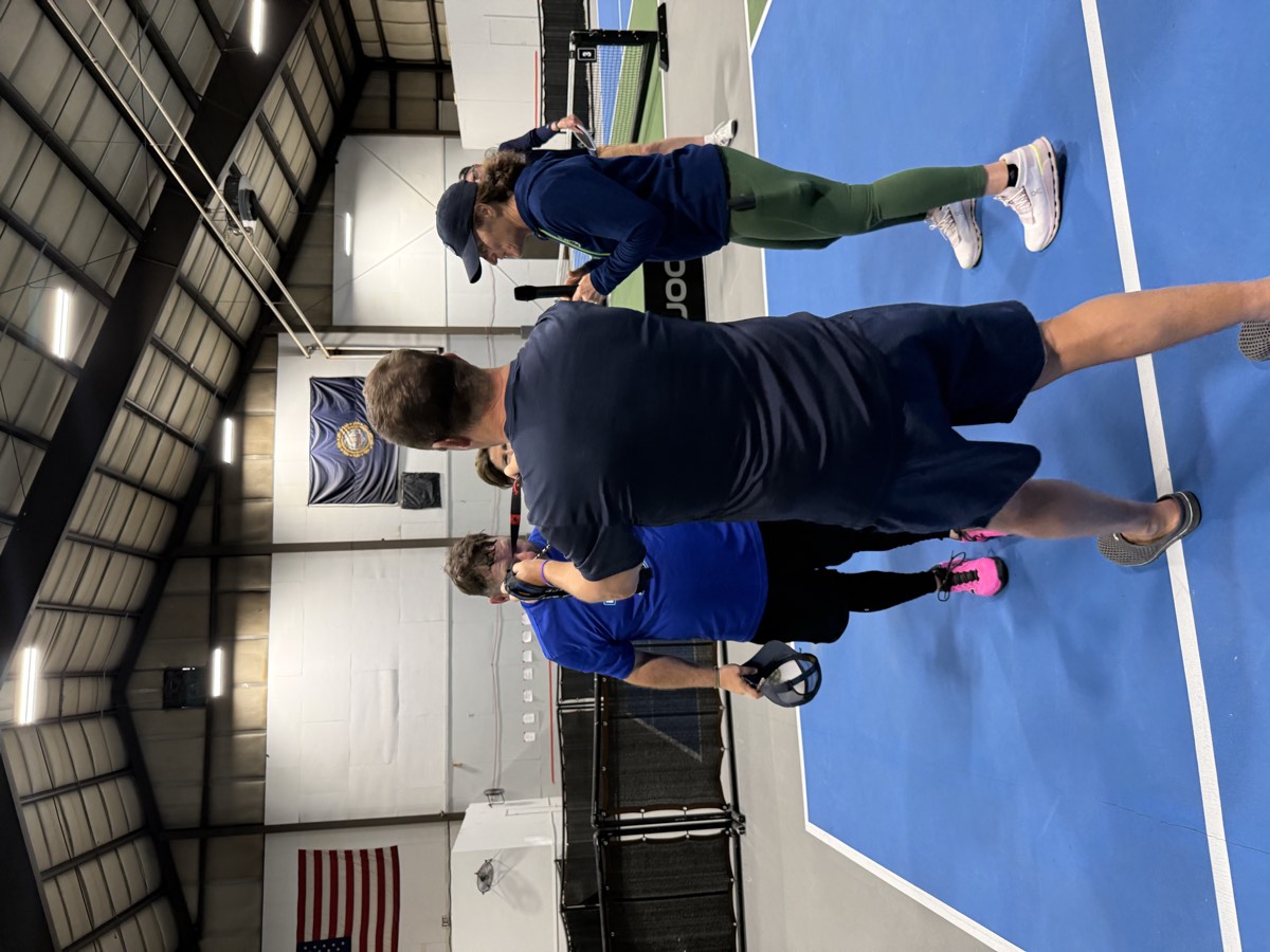 Players and a coach on the courts during a WMPC event