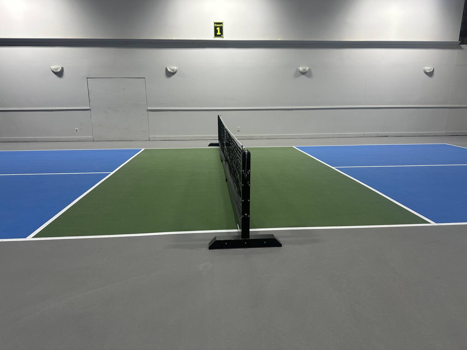 An indoor court and net at White Mountain Pickleball Club
