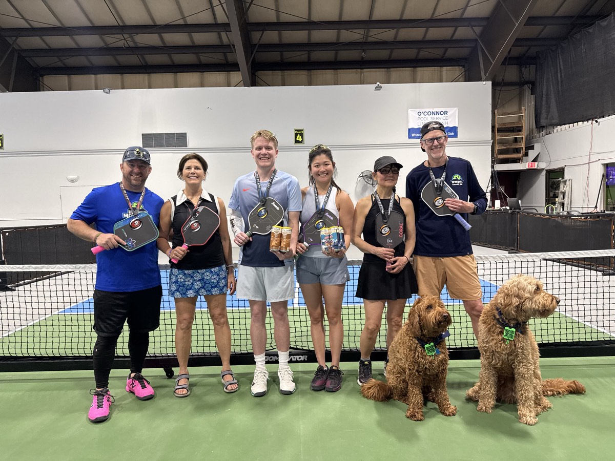 A couple with paddles and their dogs courtside at WMPC